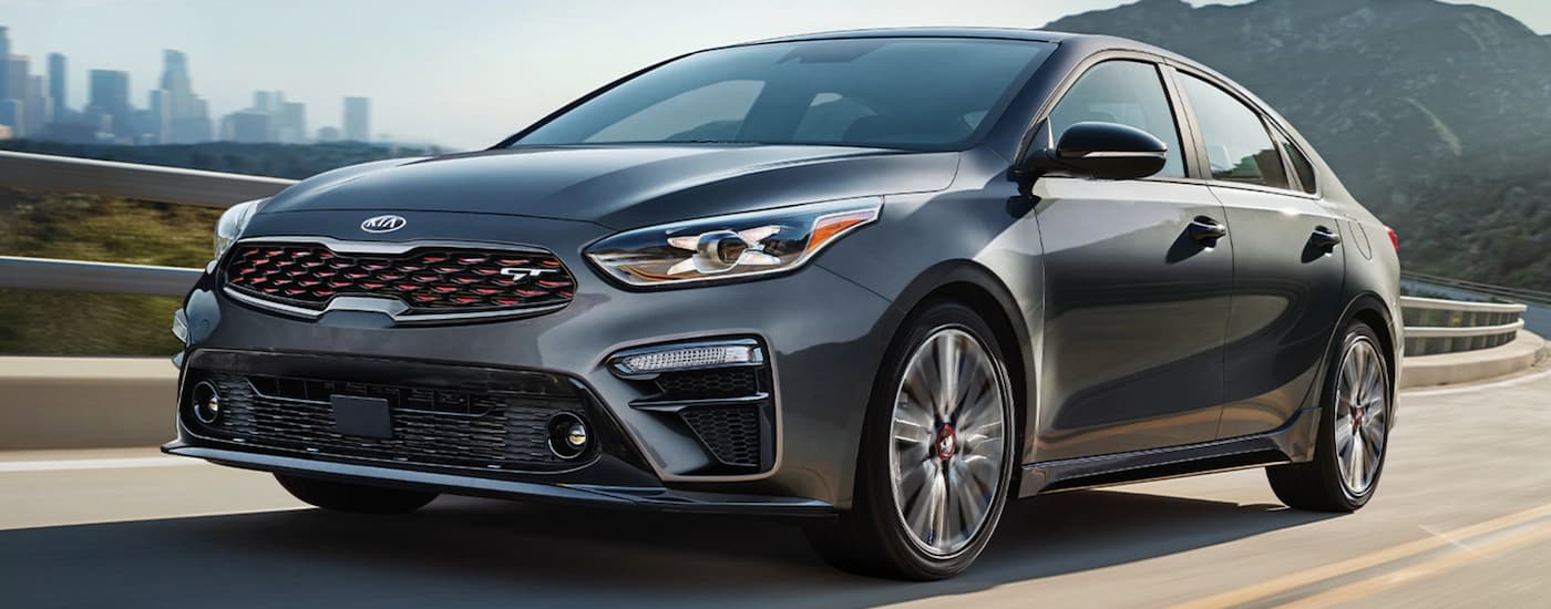 A grey 2020 Kia Forte GT is shown driving down the road after leaving a Kia Forte dealer.