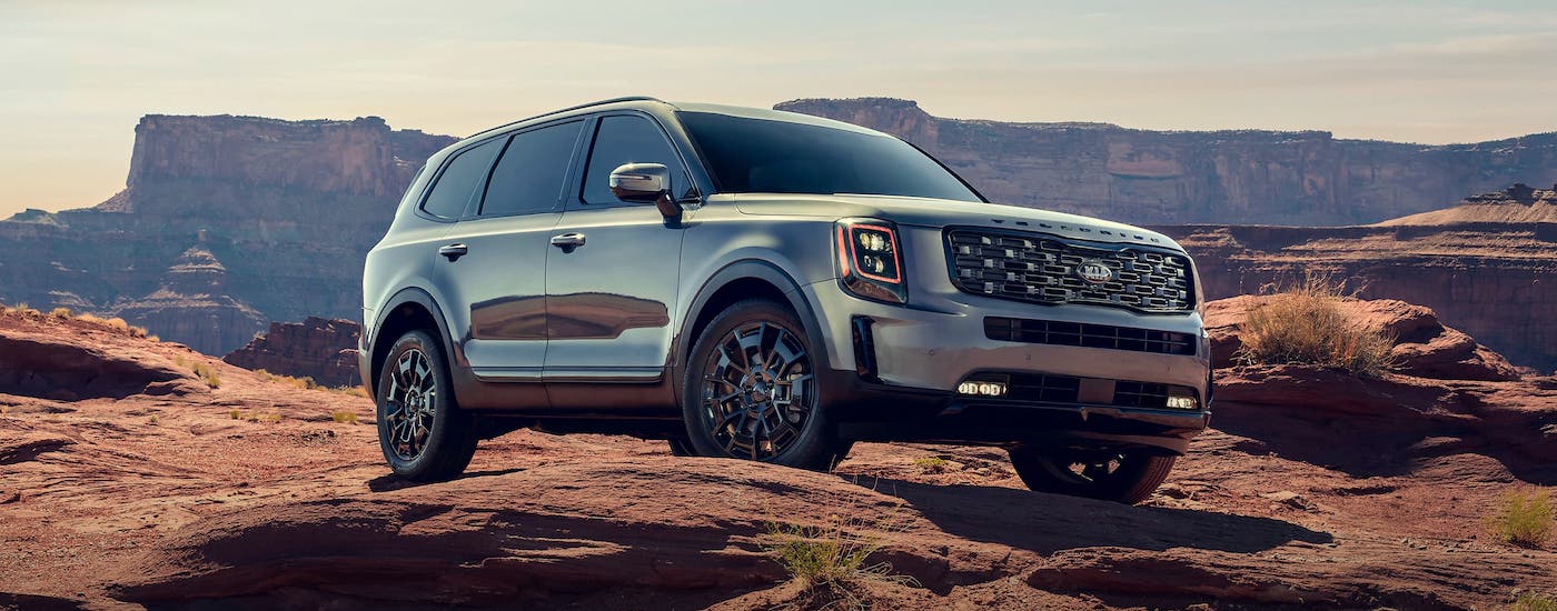 A silver 2021 Kia Telluride is parked on rocks in front of a canyon.