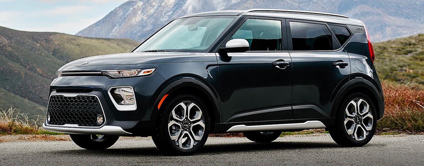 A black 2020 Kia Soul is parked in front of distant mountains.